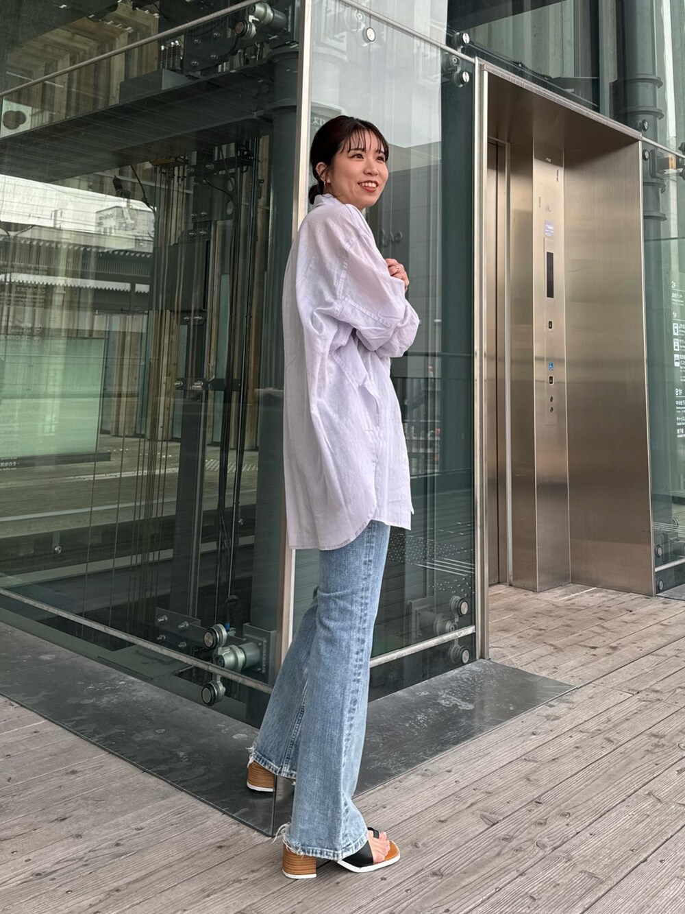 グレー系のTシャツ/カットソー、ブルー系のデニムパンツ、ブラック系のサンダルを着用したレディースの春コーディネートの5枚目の写真