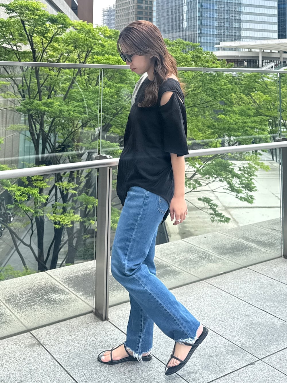 ブラック系のTシャツ/カットソー、ブルー系のデニムパンツを着用したレディースの春コーディネートの5枚目の写真