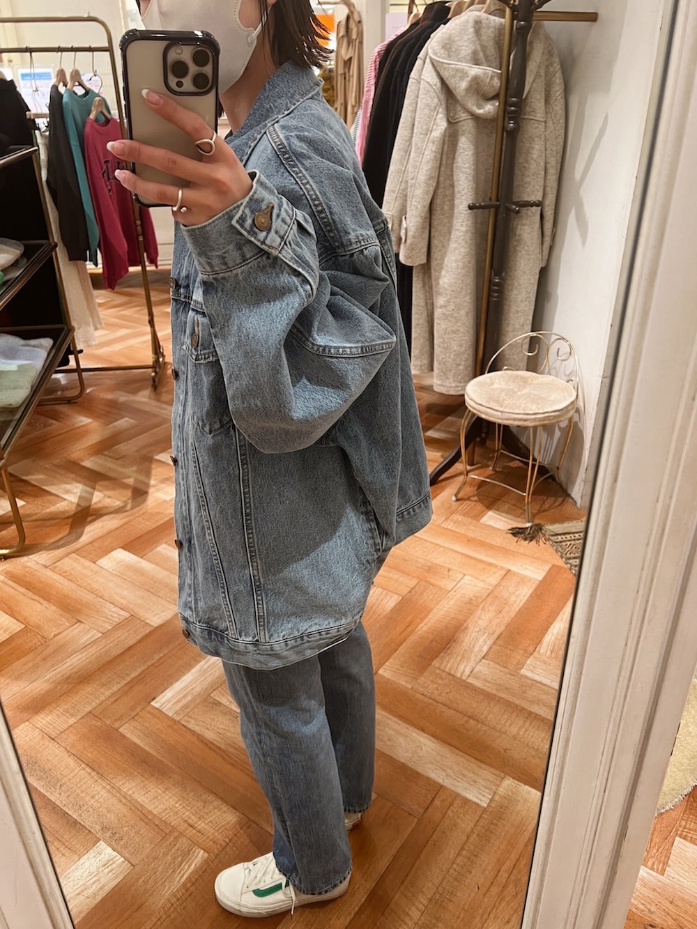 ホワイト系のデニムジャケット、グレー系のニット/セーター、ブルー系のデニムパンツを着用したレディースの冬コーディネートの4枚目の写真