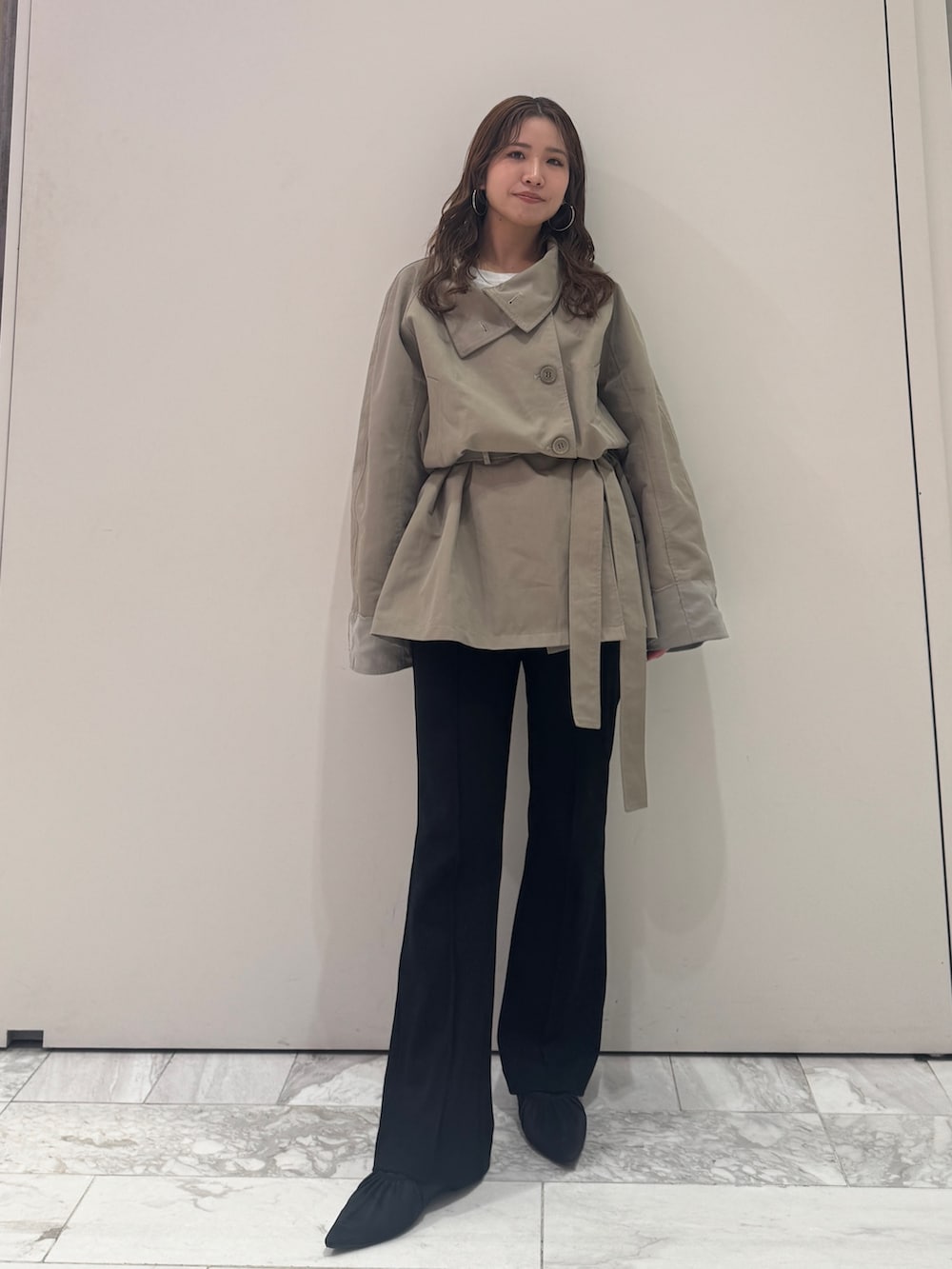 グリーン系のトレンチコート、ブラック系のその他パンツ、ブラック系のパンプスを着用したレディースの春コーディネートの2枚目の写真