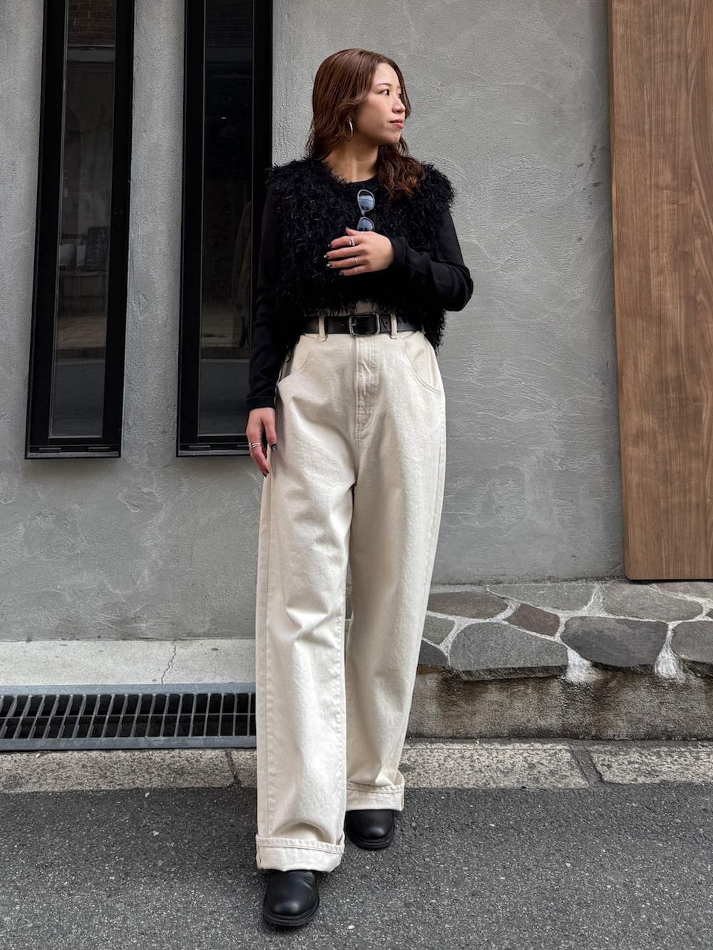 ホワイト系のデニムパンツ、ブラック系のニット/セーター、ブラック系のTシャツ/カットソーを着用したレディースの冬コーディネートの2枚目の写真