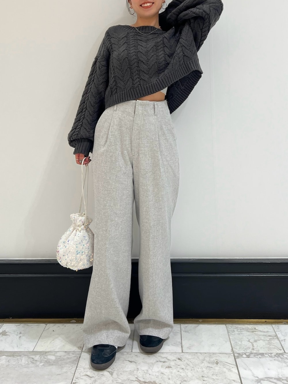 グレー系のその他パンツ、グレー系のニット/セーター、ホワイト系のハンドバッグを着用したレディースの冬コーディネートの2枚目の写真