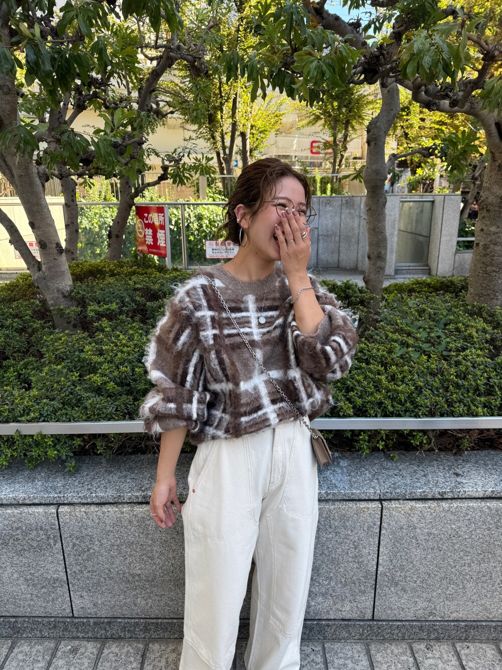 ブラウン系のニット/セーター、ホワイト系のデニムパンツを着用したレディースの秋コーディネートの10枚目の写真