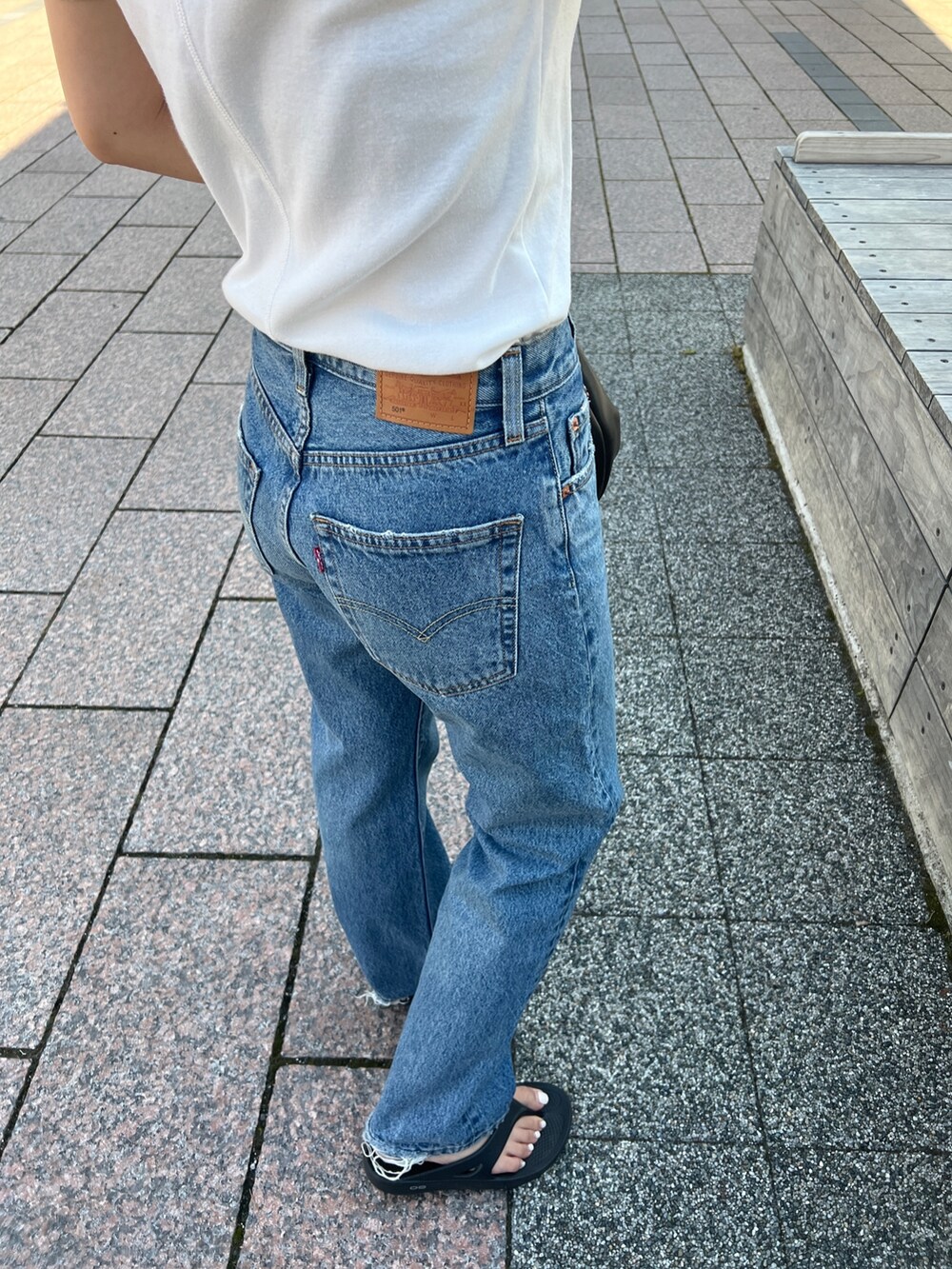 ブルー系のデニムパンツ、ホワイト系のTシャツ/カットソーを着用したレディースの夏コーディネートの9枚目の写真