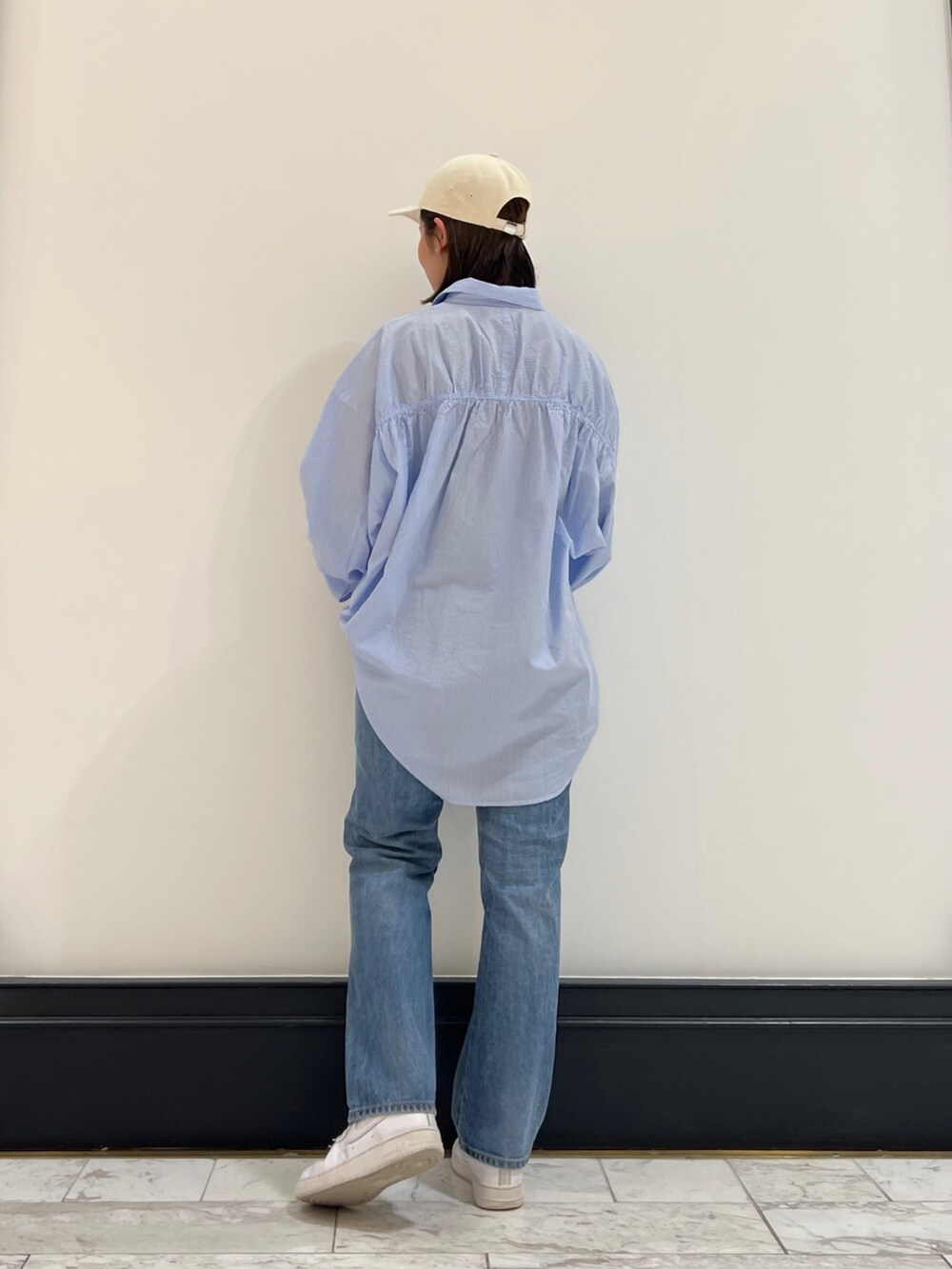 ブルー系のデニムパンツ、その他のシャツ/ブラウス、ホワイト系のキャップを着用したレディースの春コーディネートの2枚目の写真