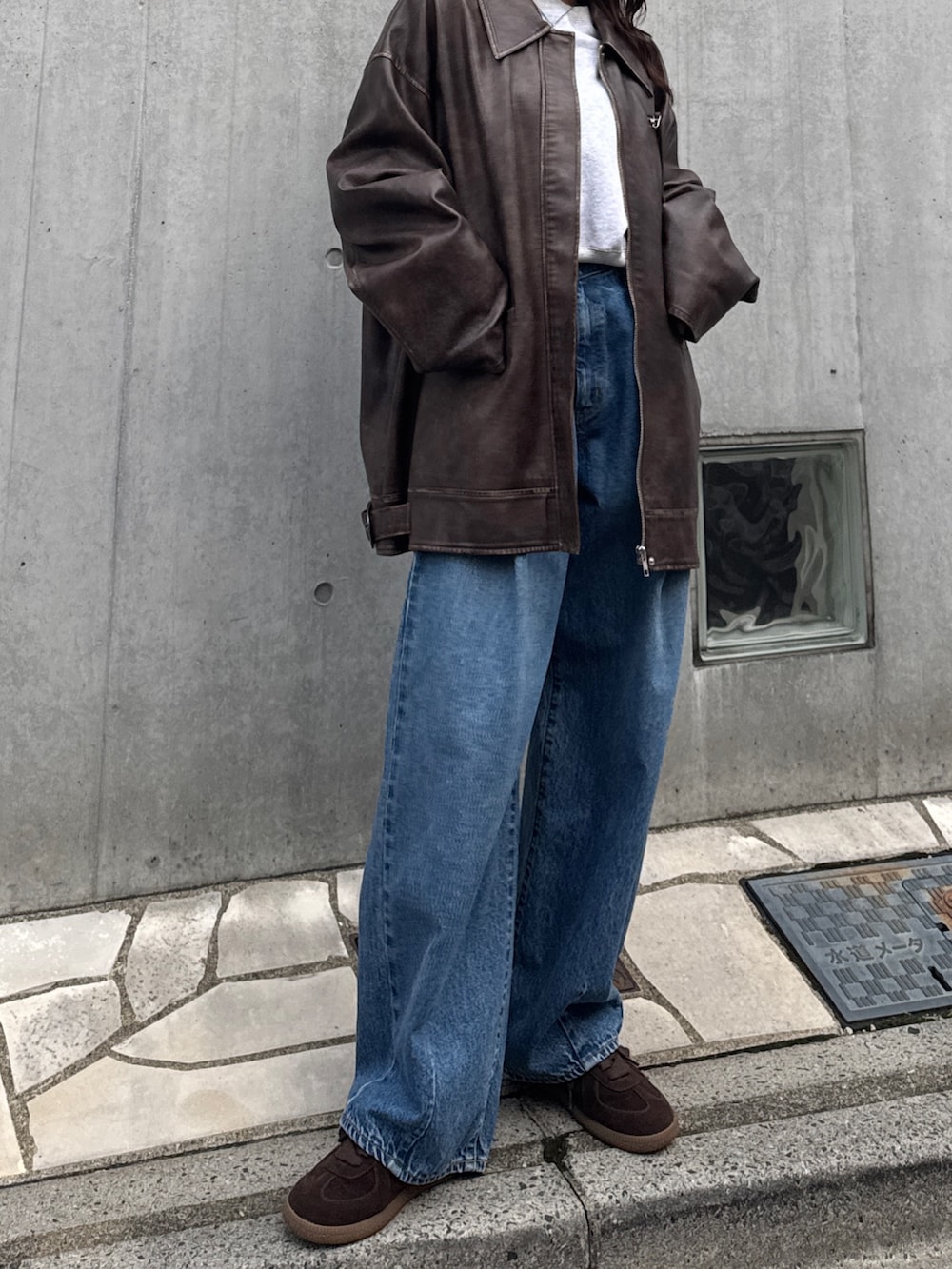 ブルー系のデニムパンツ、グレー系のスウェット、ブラウン系のブルゾンを着用したレディースの秋コーディネートの3枚目の写真