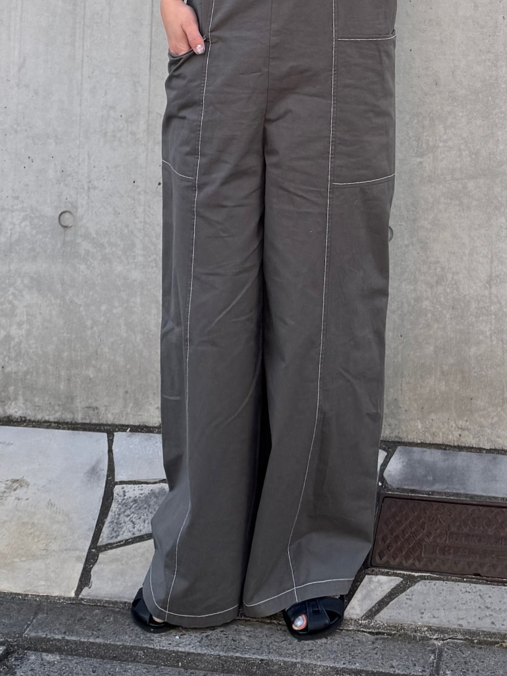 ピンク系のTシャツ/カットソー、ブラック系のサロペット/オーバーオール、ブラック系のサンダルを着用したレディースの春コーディネートの5枚目の写真