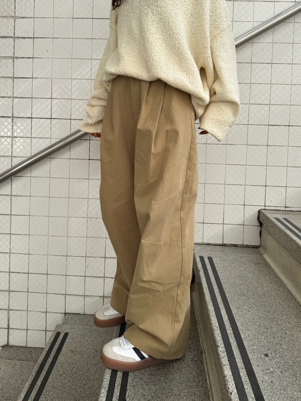 ベージュ系のチノパンツ、ホワイト系のニット/セーター、オレンジ系のエコバッグ/サブバッグを着用したレディースの冬コーディネートの8枚目の写真