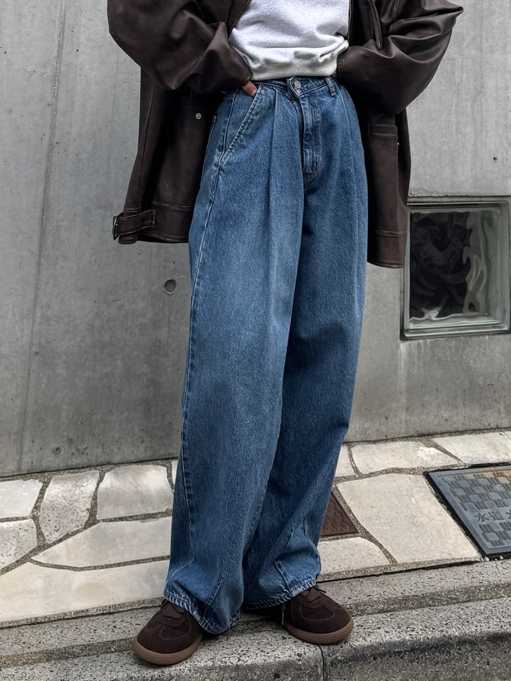 ブルー系のデニムパンツ、グレー系のスウェット、ブラウン系のブルゾンを着用したレディースの秋コーディネートの6枚目の写真