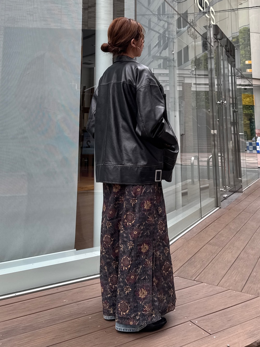 ブラック系のブルゾン、ブラック系のワンピース、ブルー系のデニムパンツを着用したレディースの冬コーディネートの3枚目の写真