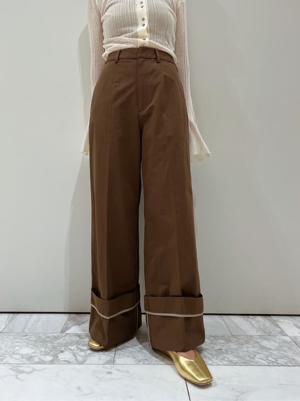 ブラウン系のチノパンツ、ゴールド系のパンプス、ホワイト系のカーディガン/ボレロを着用したレディースの夏コーディネートの7枚目の写真