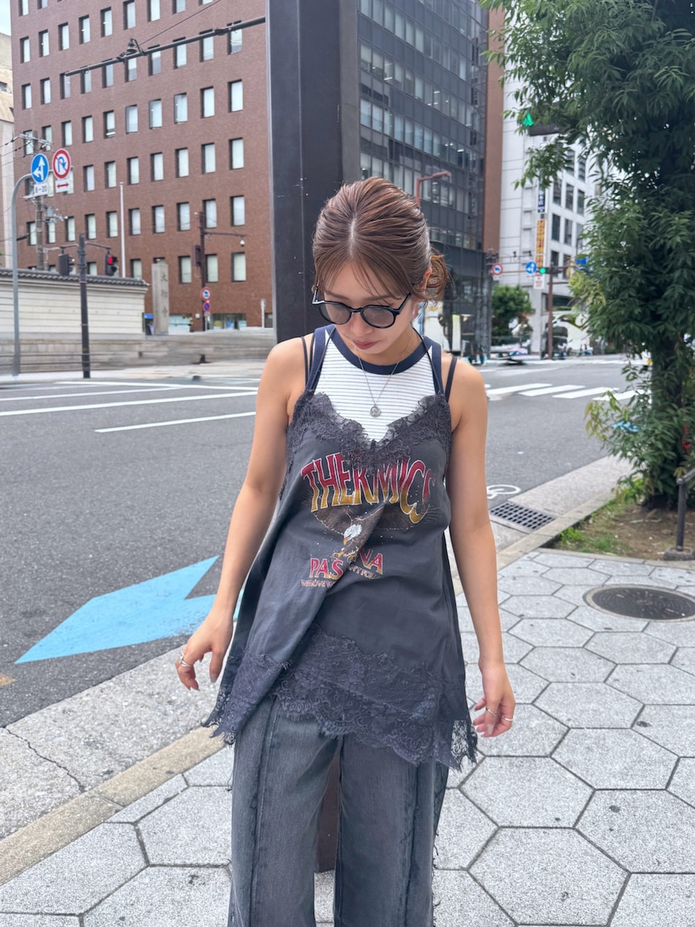 グレー系のキャミソール、ホワイト系のタンクトップ、ブラック系のデニムパンツを着用したレディースの夏コーディネートの9枚目の写真