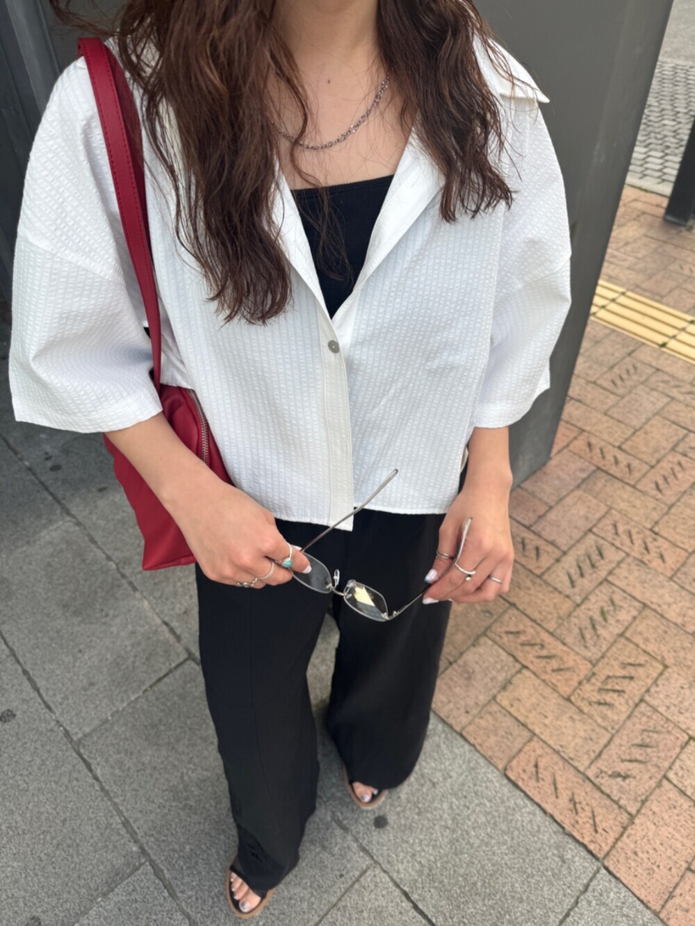 ブラック系のその他パンツ、ホワイト系のシャツ/ブラウス、レッド系のハンドバッグを着用したレディースの春コーディネートの10枚目の写真