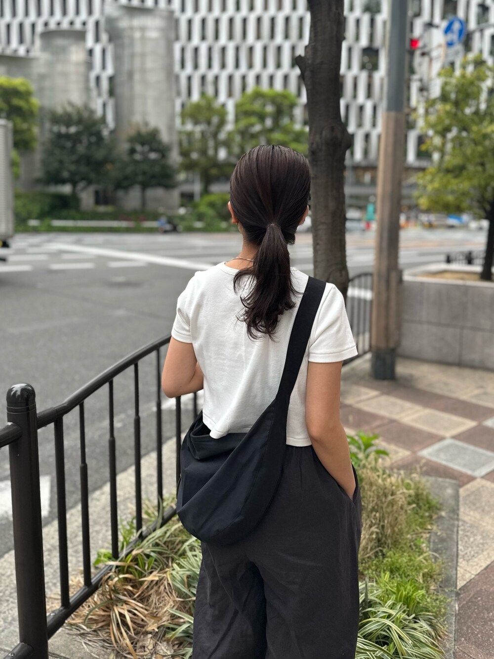 ホワイト系のTシャツ/カットソー、グレー系のその他パンツ、ブラック系のサンダルを着用したレディースの春コーディネートの8枚目の写真