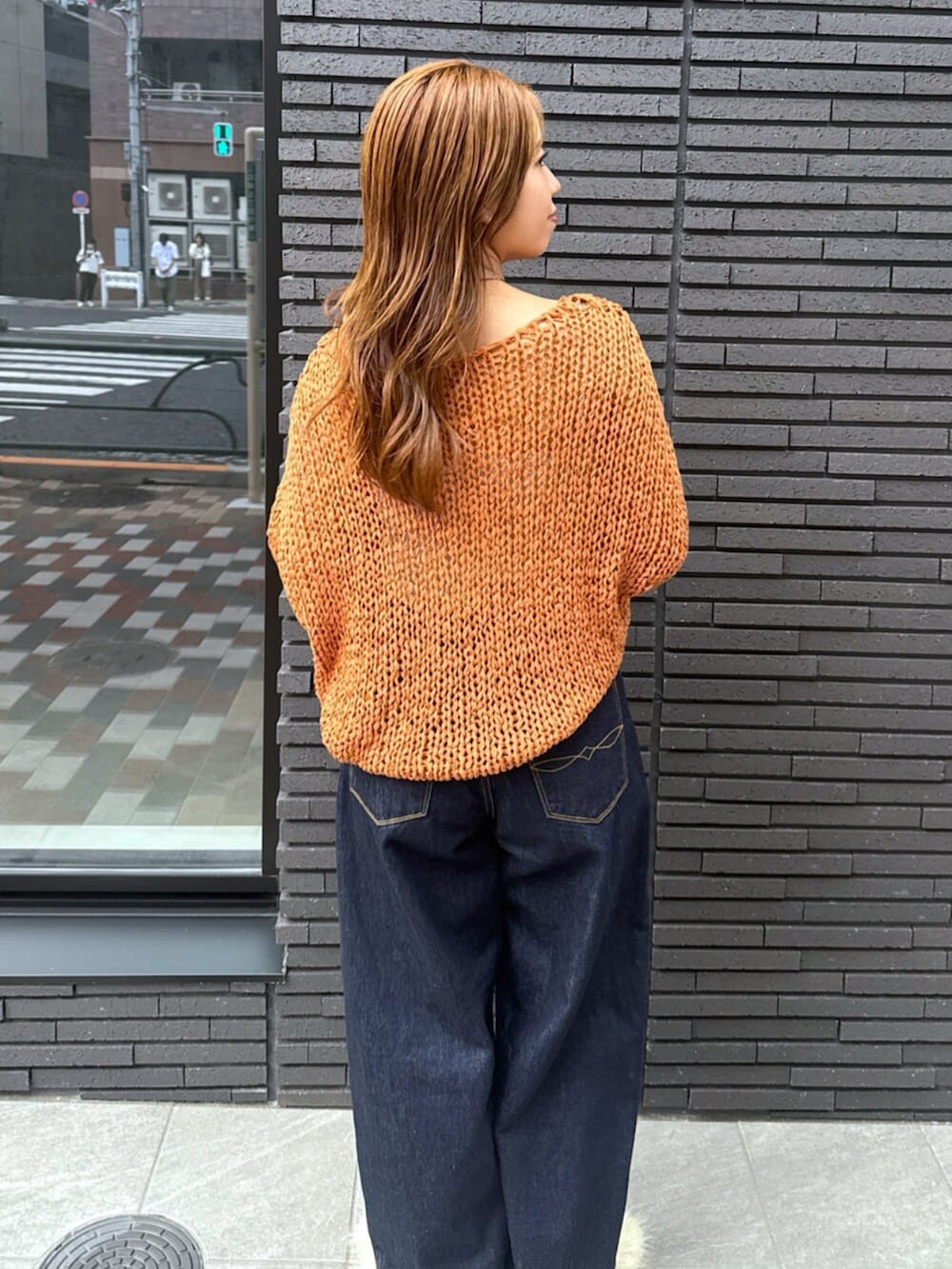 ホワイト系のその他シューズ、ブルー系のデニムパンツ、オレンジ系のニット/セーターを着用したレディースの夏コーディネートの8枚目の写真