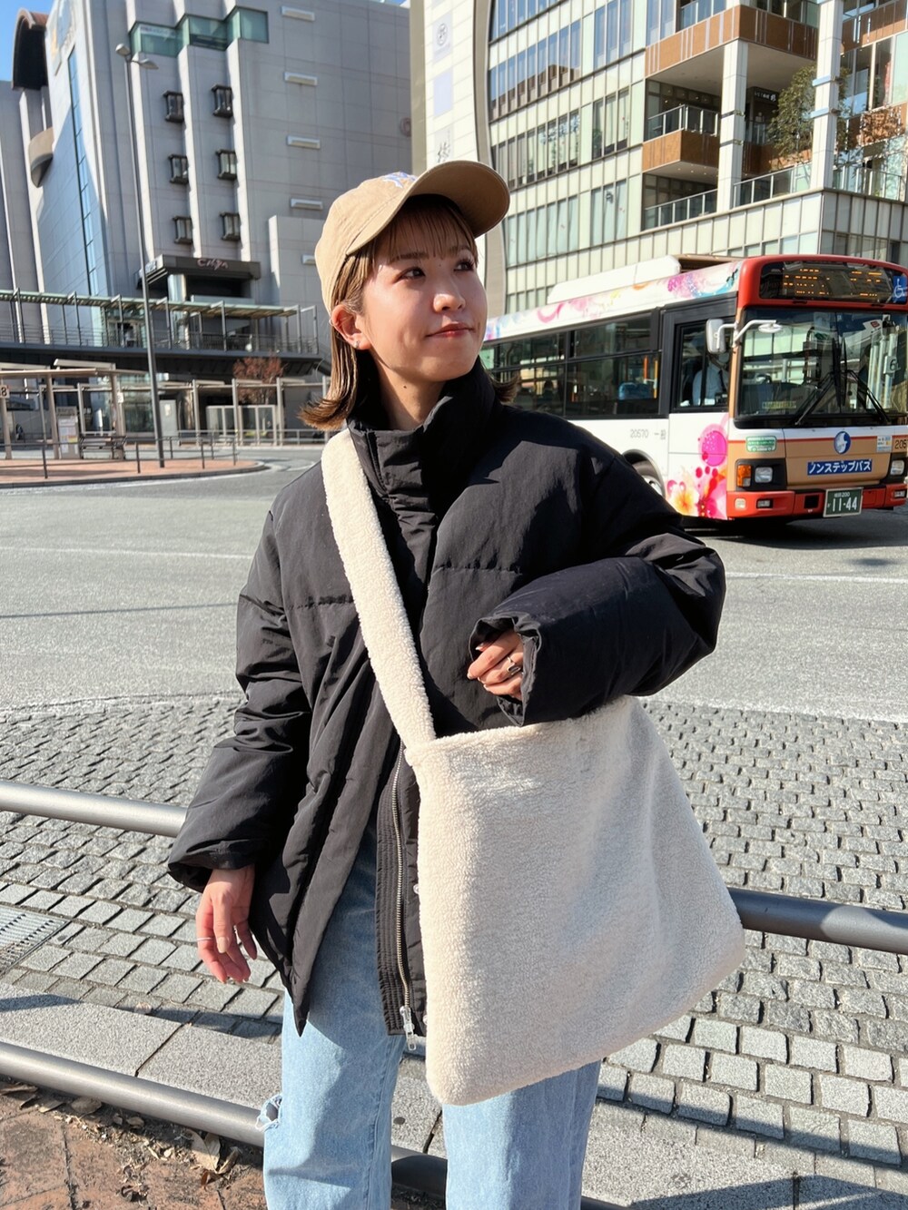 ブラック系のダウンジャケット/コート、ホワイト系のショルダーバッグ、ブルー系のデニムパンツを着用したレディースの秋コーディネートの8枚目の写真