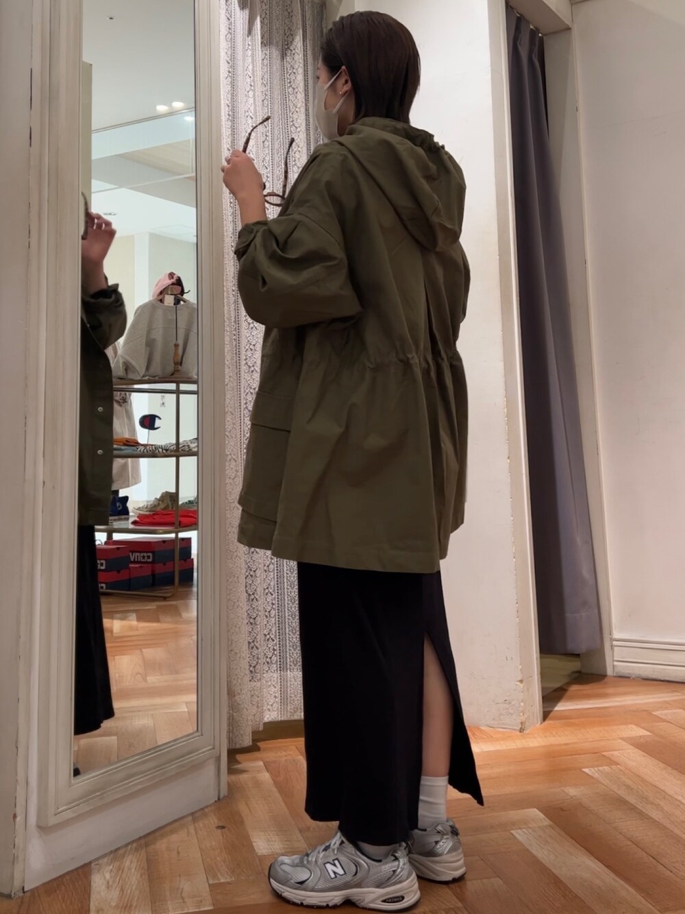 ブラック系のワンピース、グリーン系のブルゾン、ブラウン系のメガネを着用したレディースの冬コーディネートの3枚目の写真