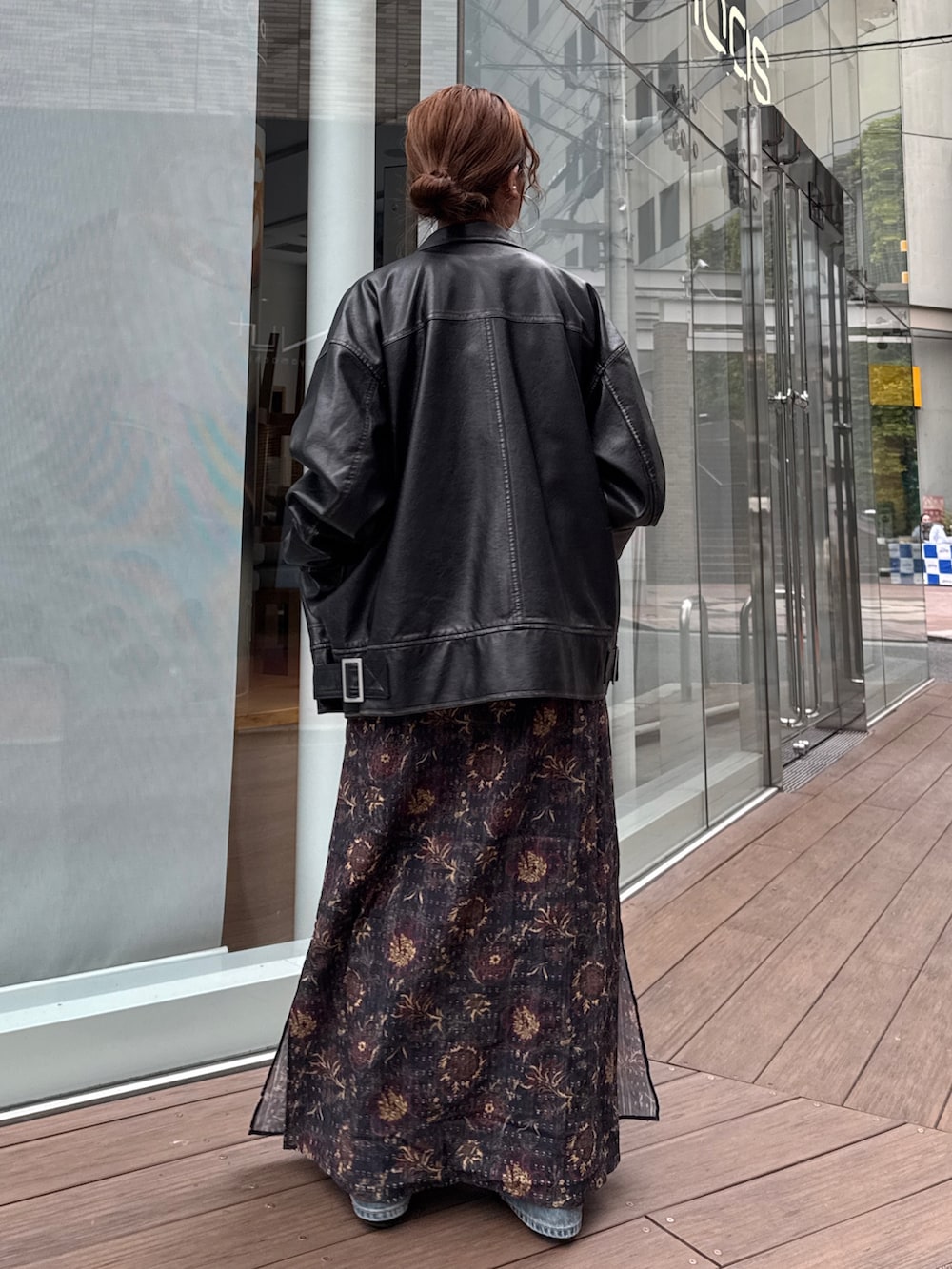 ブラック系のブルゾン、ブラック系のワンピース、ブルー系のデニムパンツを着用したレディースの冬コーディネートの4枚目の写真