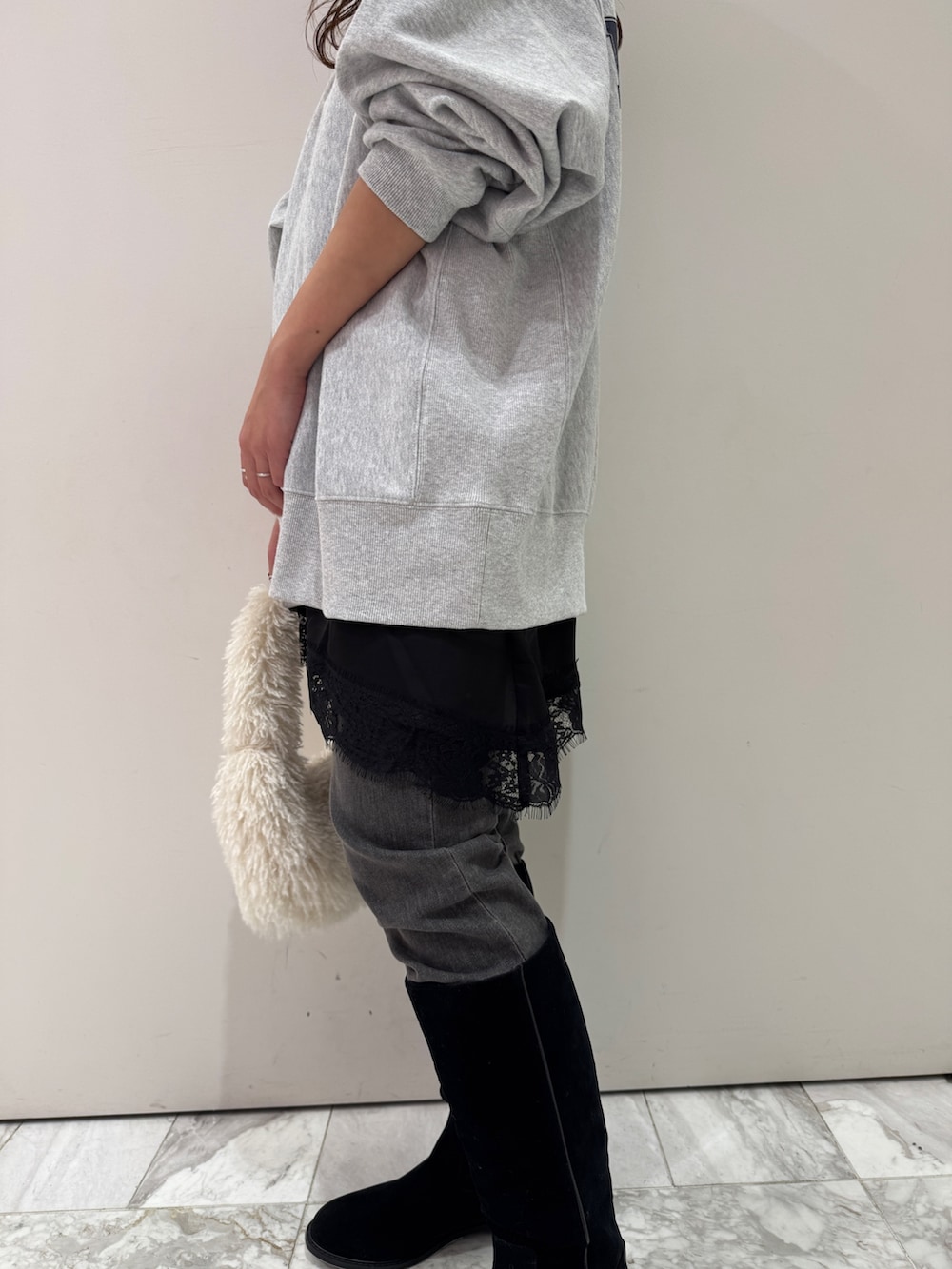 グレー系のスウェット、ブラック系のキャミソール、ブラック系のデニムパンツを着用したレディースの冬コーディネートの8枚目の写真