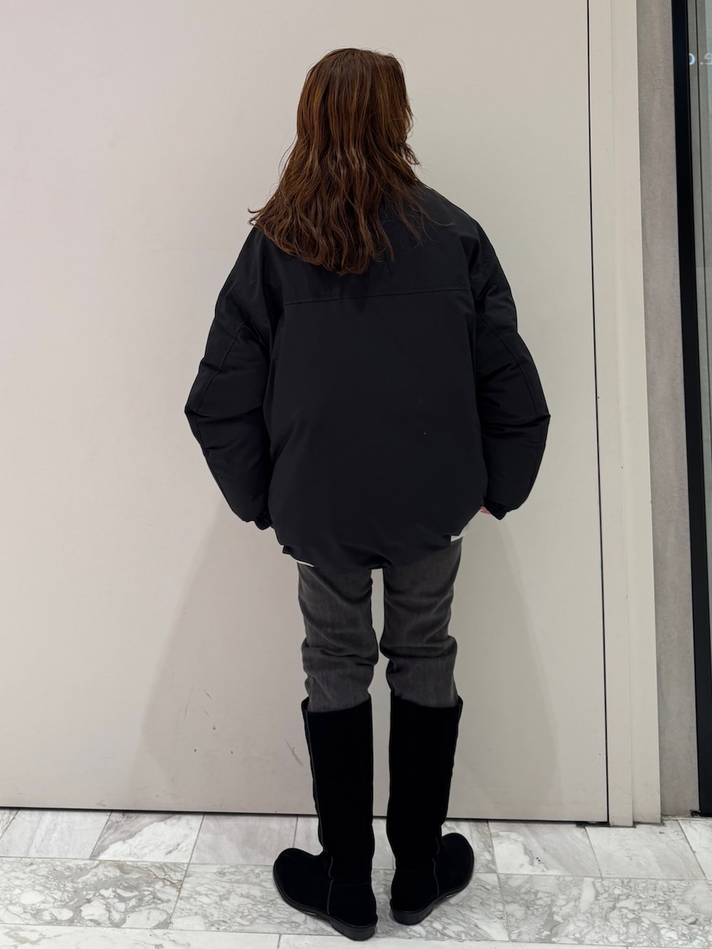 ブラック系のブルゾン、グレー系のスウェット、ブラック系のデニムパンツを着用したレディースの冬コーディネートの4枚目の写真