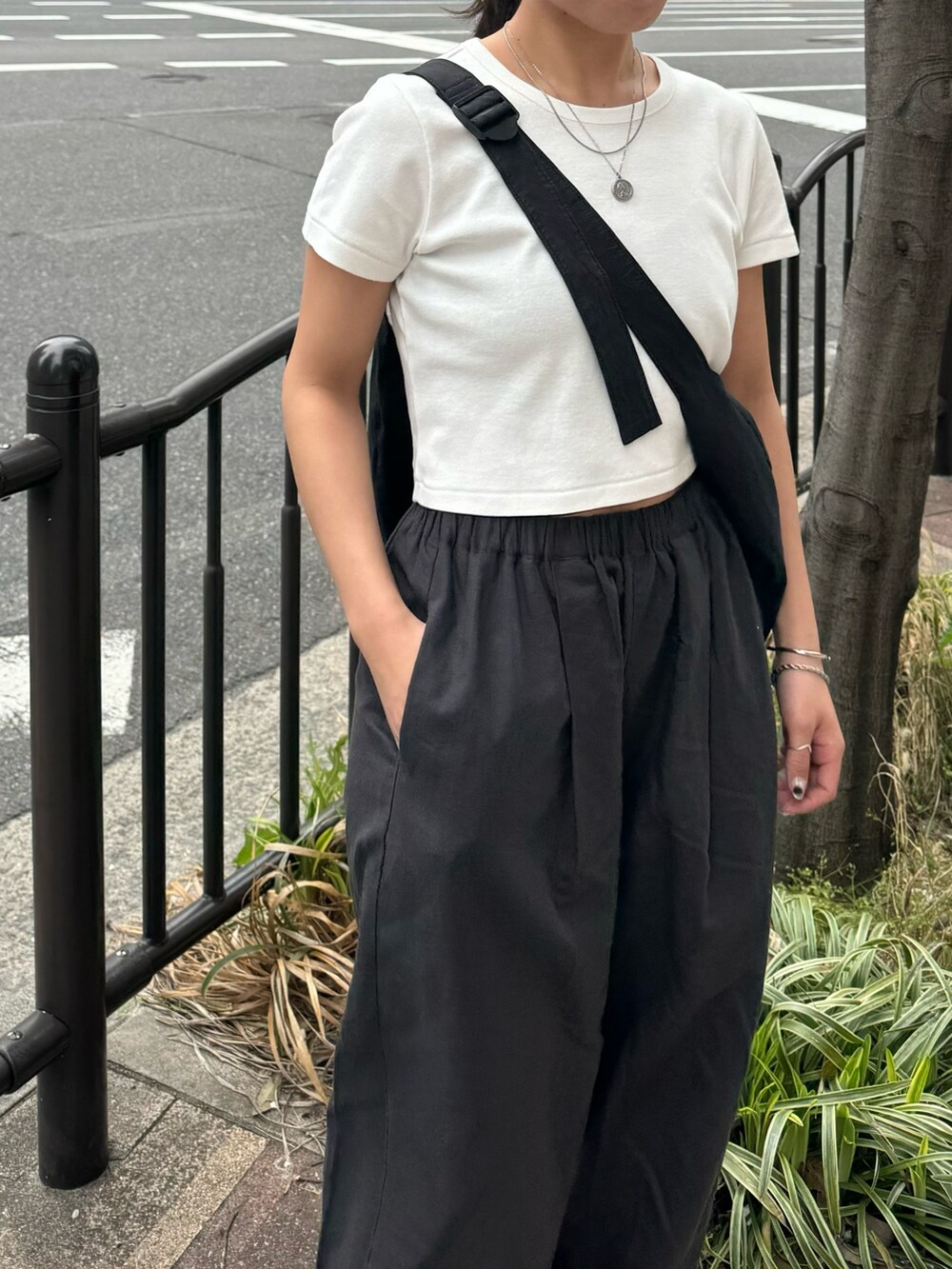 ホワイト系のTシャツ/カットソー、グレー系のその他パンツ、ブラック系のサンダルを着用したレディースの春コーディネートの3枚目の写真