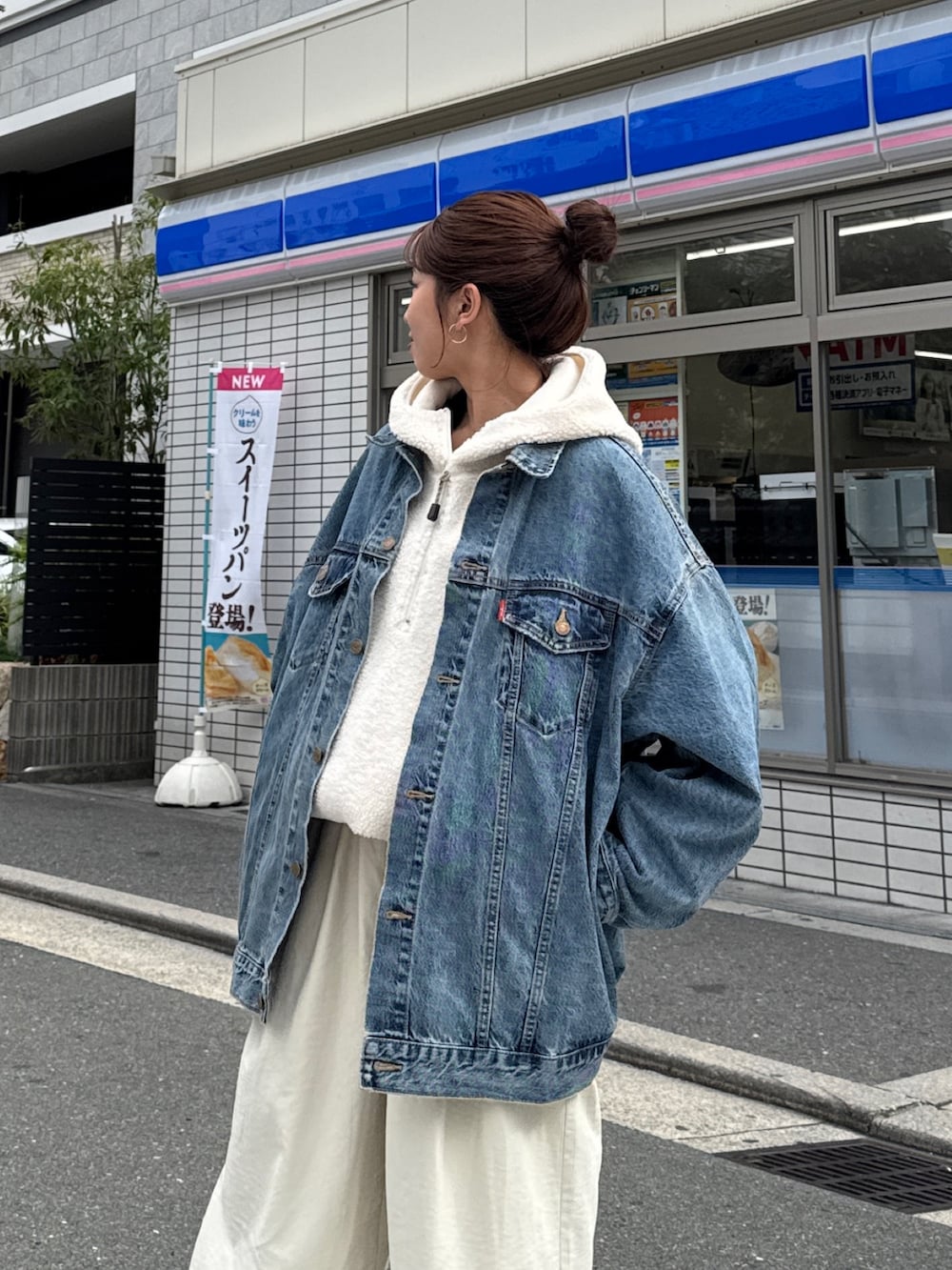 ブルー系のデニムジャケット、ホワイト系のパーカー、ホワイト系のその他パンツを着用したレディースの秋コーディネートの3枚目の写真