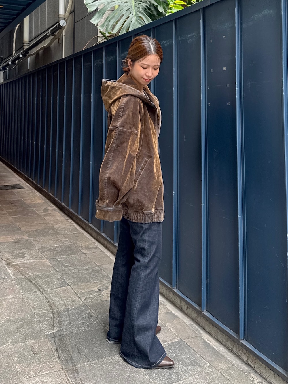ブラック系のニット/セーター、ブラウン系のブルゾン、ブルー系のデニムパンツを着用したレディースの秋コーディネートの2枚目の写真