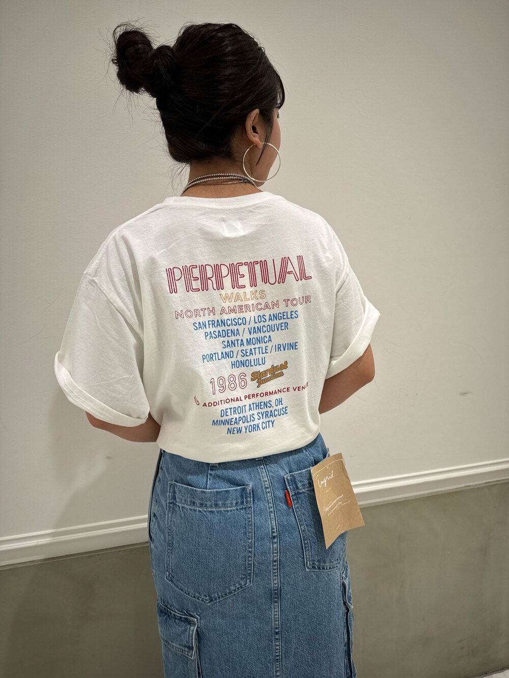 ブルー系のデニムスカート、ホワイト系のTシャツ/カットソー、ブルー系のスニーカーを着用したレディースの春コーディネートの8枚目の写真