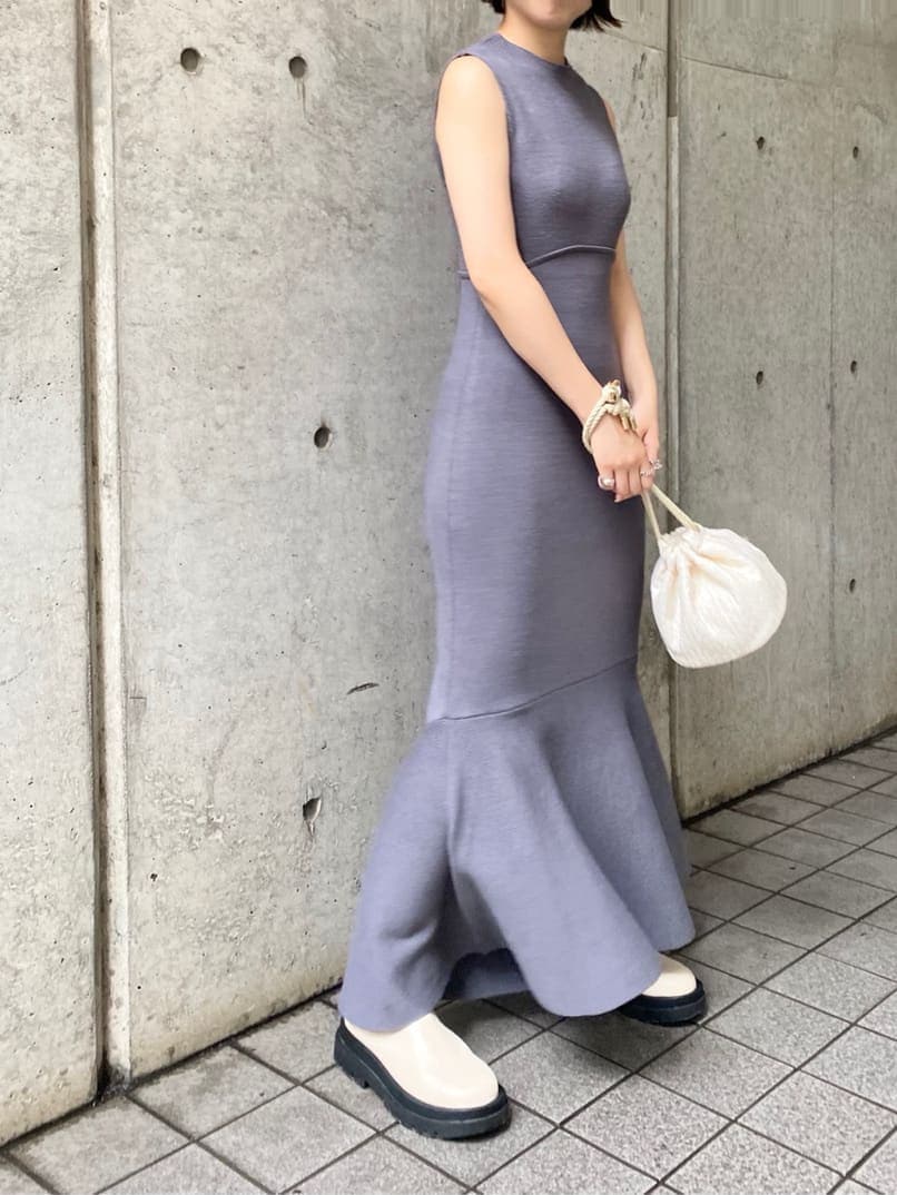 ホワイト系のハンドバッグ、ブルー系のワンピース、ホワイト系のブーツを着用したレディースの秋コーディネートの3枚目の写真