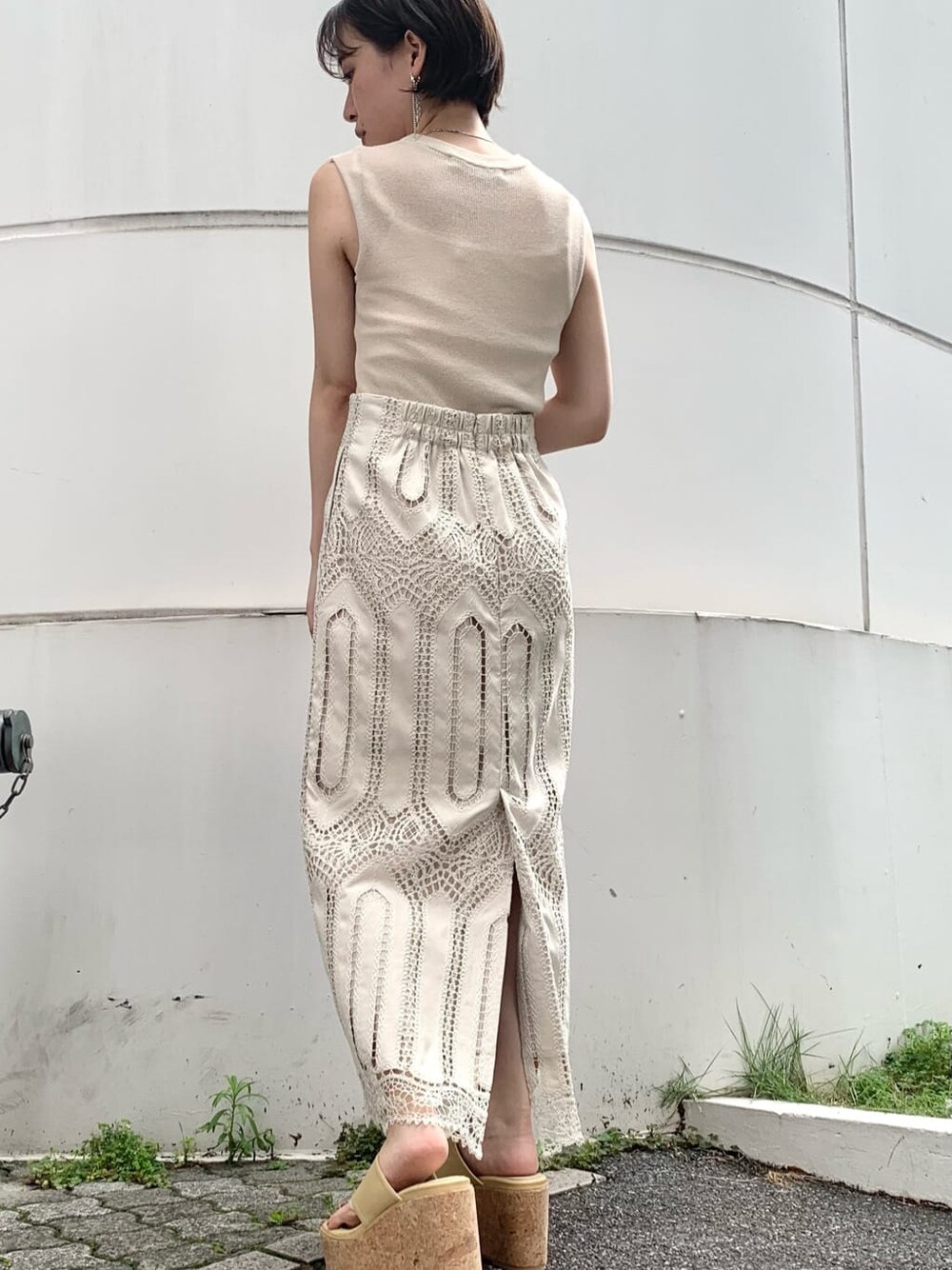 ホワイト系のスカート、イエロー系のサンダル、ベージュ系のニット/セーターを着用したレディースの夏コーディネートの2枚目の写真