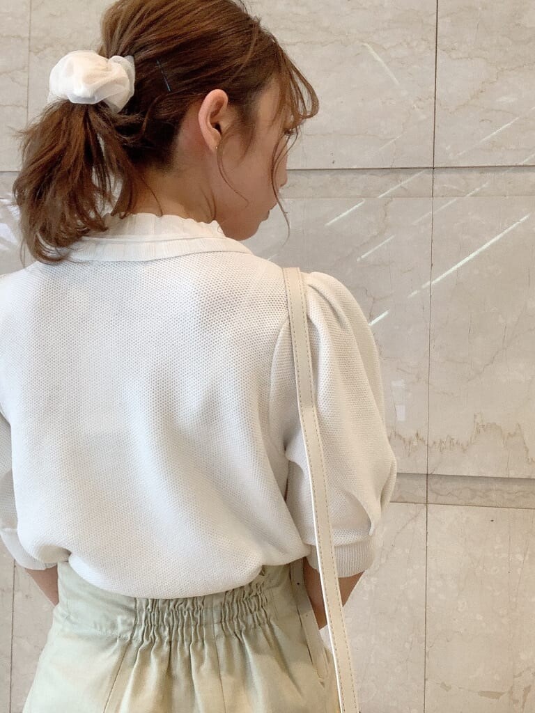 グリーン系のスカート、ホワイト系のパンプス、ホワイト系のハンドバッグを着用したレディースの春コーディネートの7枚目の写真