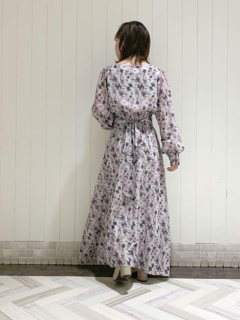 グレー系のトレンチコート、ピンク系のワンピース、ベージュ系のブーツを着用したレディースの秋コーディネートの6枚目の写真