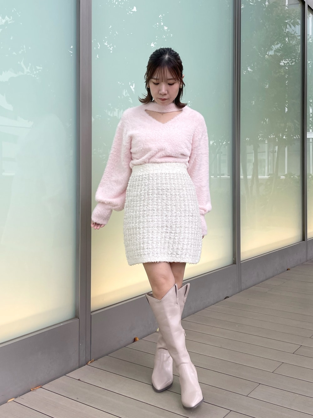 ピンク系のニット/セーター、ホワイト系のスカート、ベージュ系のブーツを着用したレディースの秋コーディネートの3枚目の写真