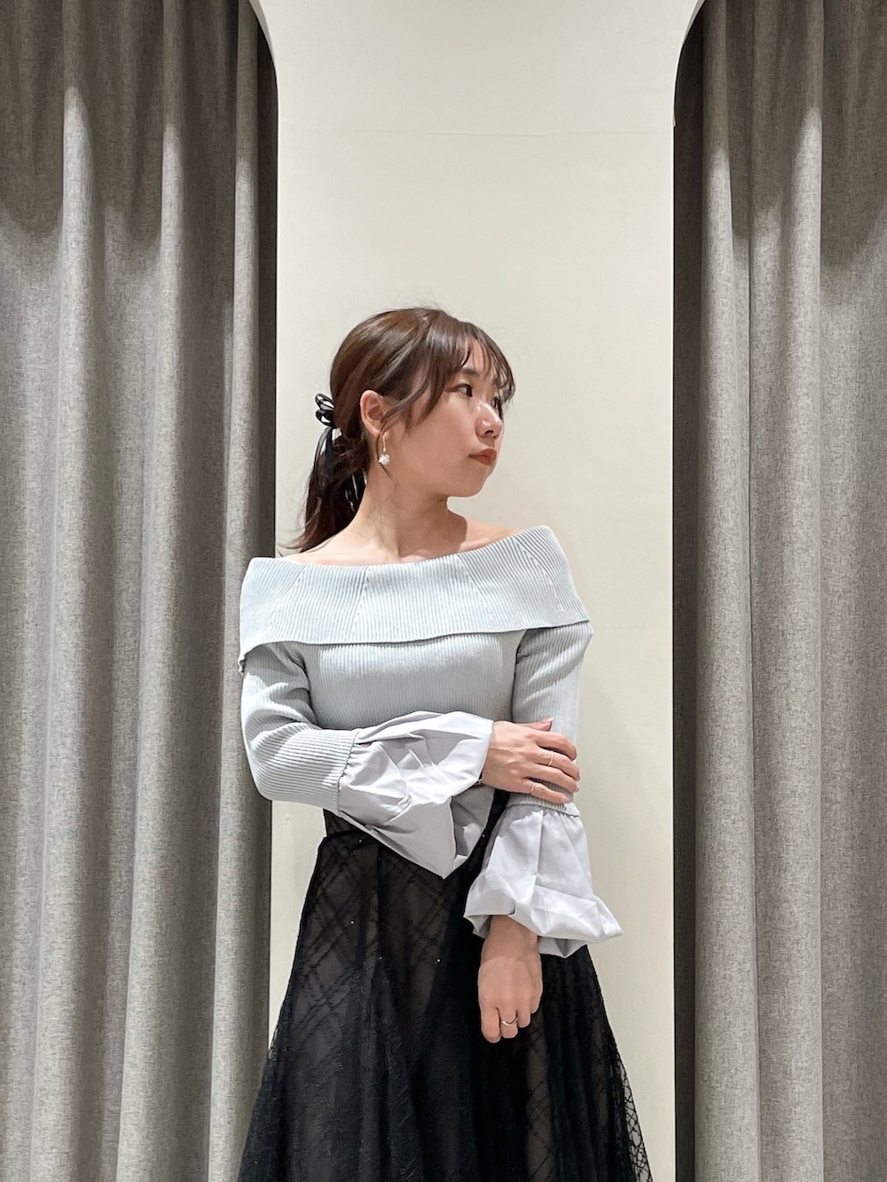 ブラック系のスカート、グレー系のニット/セーター、ブラック系のブーツを着用したレディースの春コーディネートの6枚目の写真