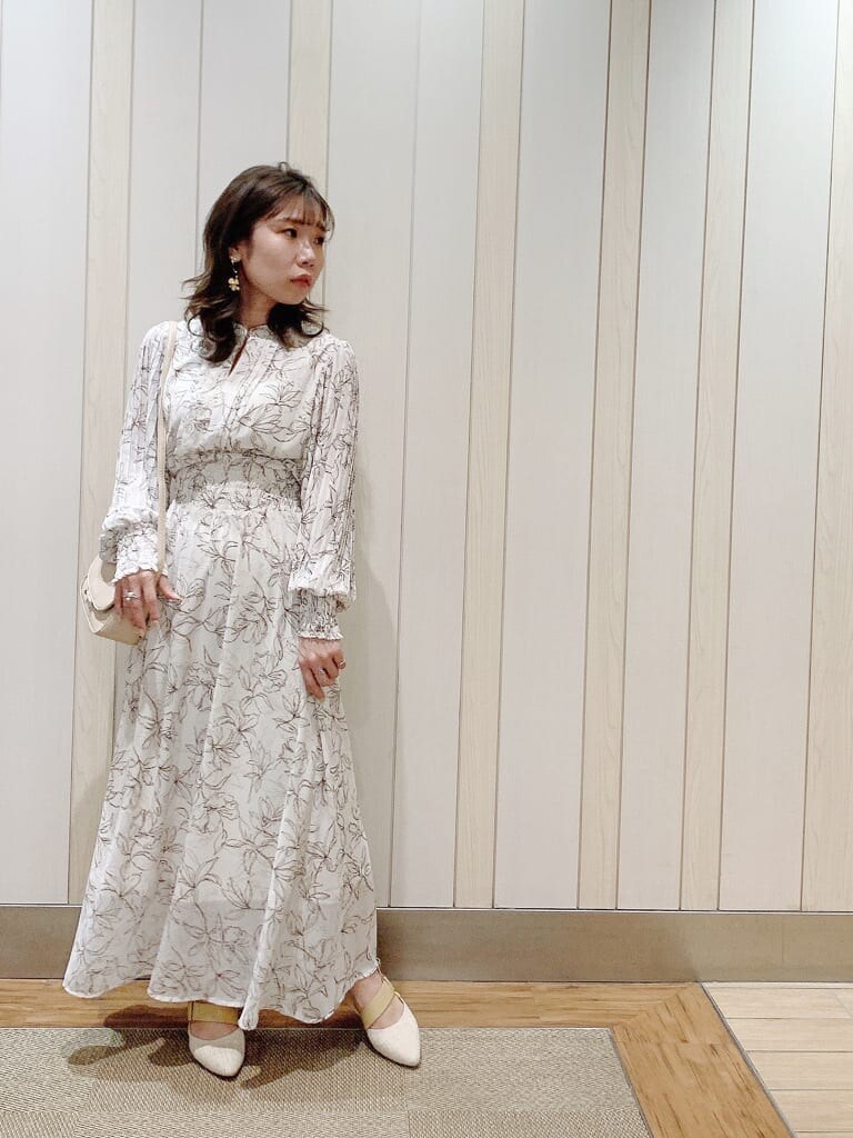 ホワイト系のワンピース、ベージュ系のパンプス、ベージュ系のショルダーバッグを着用したレディースの冬コーディネートの3枚目の写真