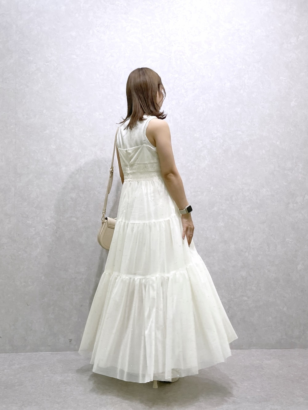 ベージュ系のパンプス、ホワイト系のハンドバッグ、ホワイト系のワンピースを着用したレディースの夏コーディネートの3枚目の写真