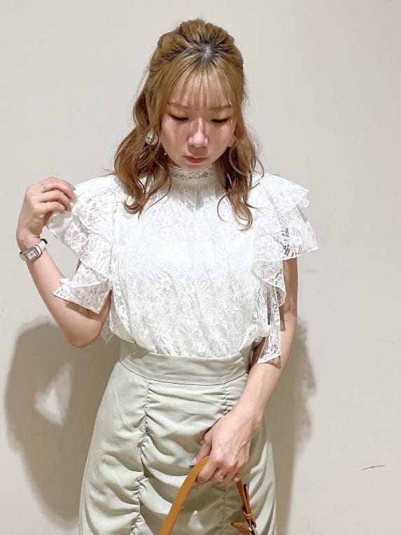 グリーン系のスカート、ブラウン系のハンドバッグ、ホワイト系のシャツ/ブラウスを着用したレディースの夏コーディネートの5枚目の写真