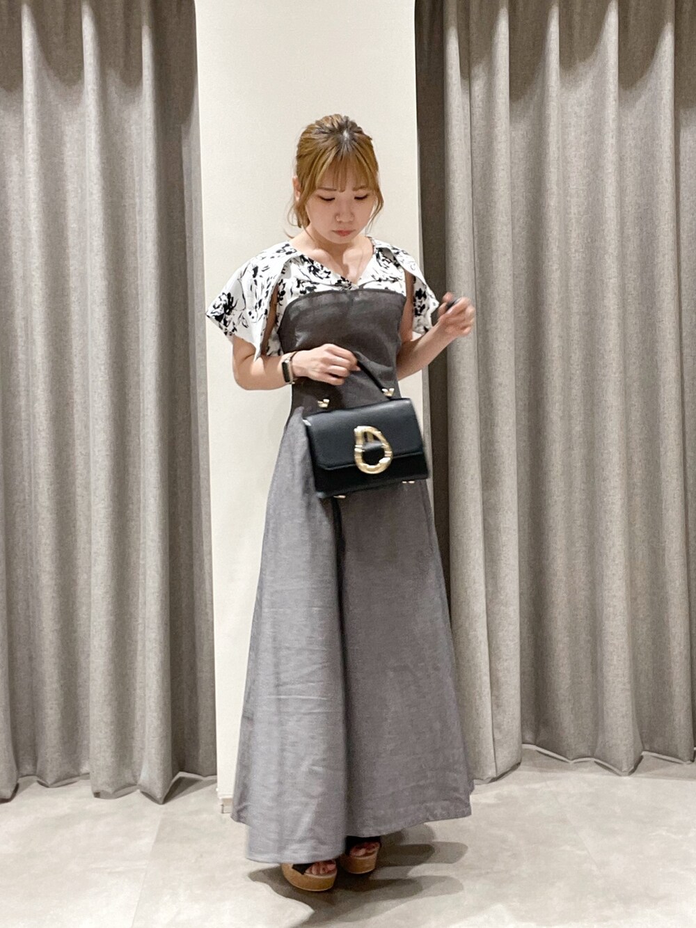 ブラック系のワンピース、ブラック系のハンドバッグ、ブラック系のサンダルを着用したレディースの夏コーディネートの5枚目の写真