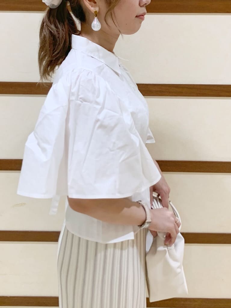 ホワイト系のシャツ/ブラウス、ホワイト系のスカート、ホワイト系のハンドバッグを着用したレディースの春コーディネートの6枚目の写真