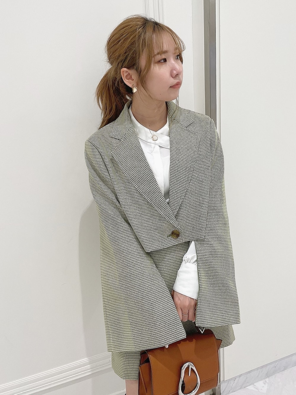 グリーン系のテーラードジャケット、ホワイト系のシャツ/ブラウス、グリーン系のスカートを着用したレディースの冬コーディネートの9枚目の写真