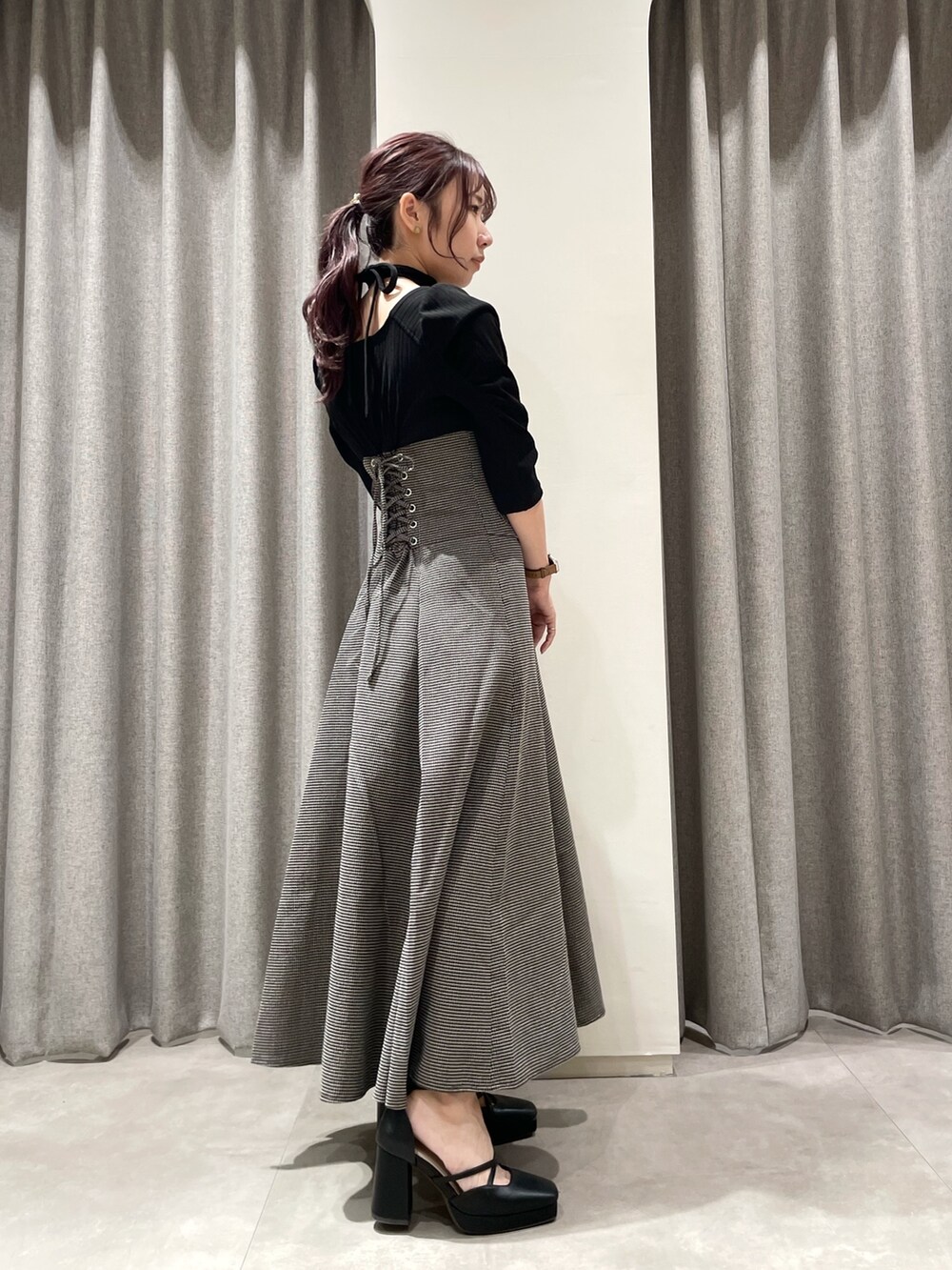 ブラック系のワンピース、ブラック系のパンプスを着用したレディースの秋コーディネートの2枚目の写真