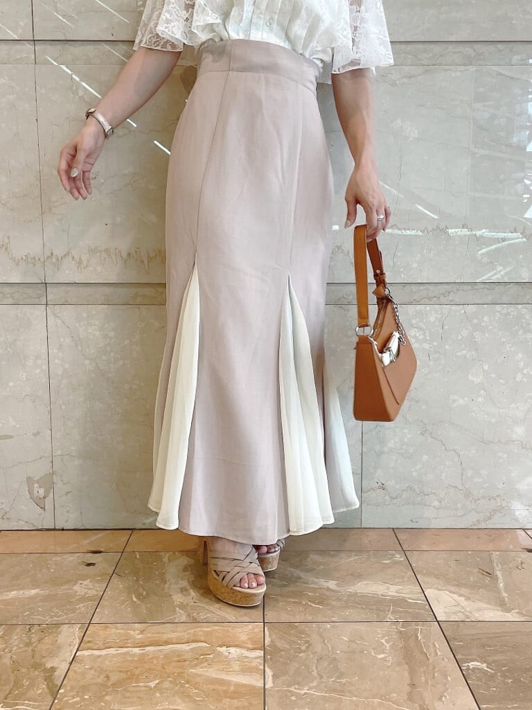 ブラウン系のハンドバッグ、ホワイト系のシャツ/ブラウス、ベージュ系のサンダルを着用したレディースの夏コーディネートの6枚目の写真