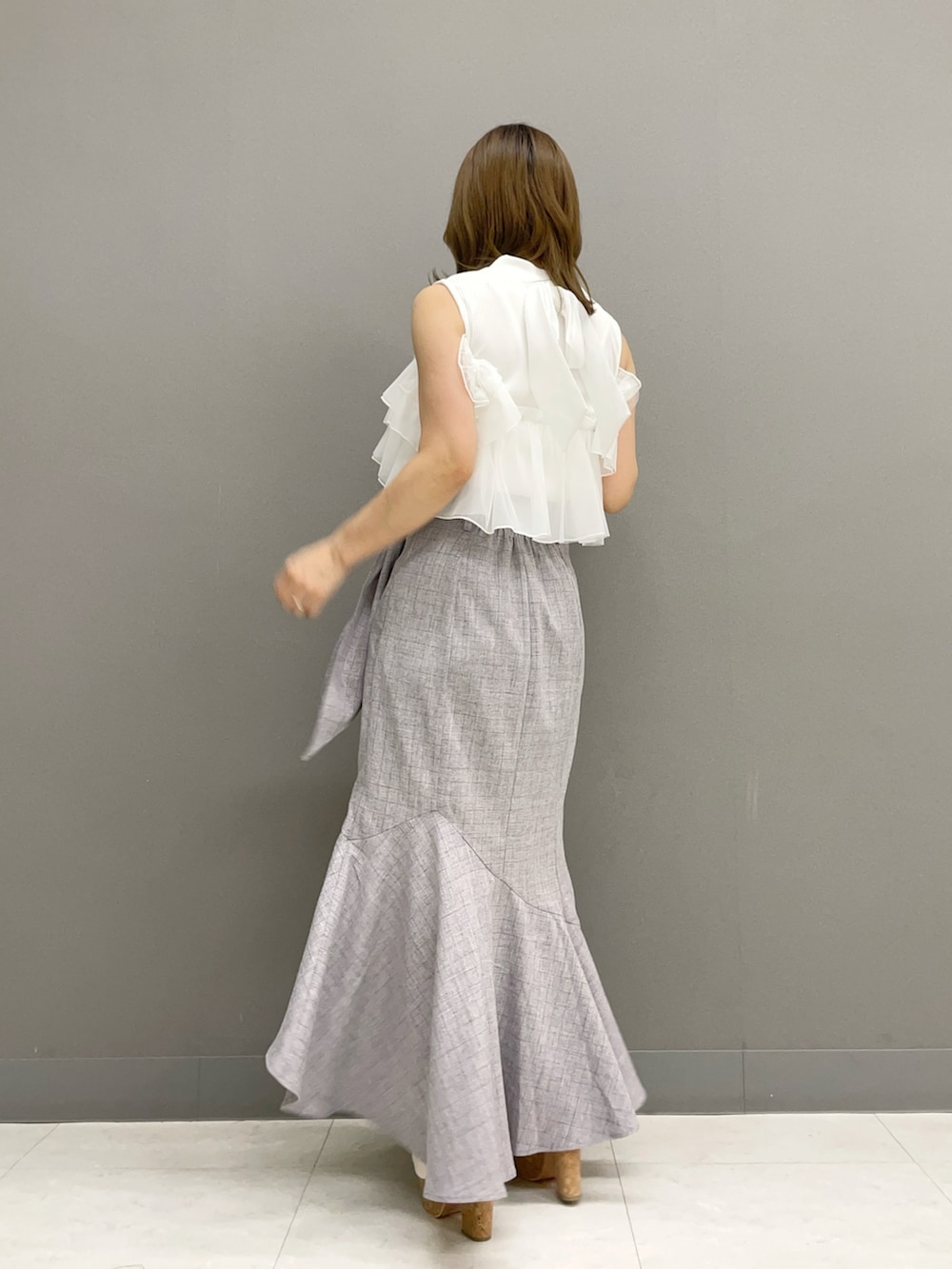 ホワイト系のTシャツ/カットソー、グレー系のスカート、ホワイト系のサンダルを着用したレディースの夏コーディネートの3枚目の写真