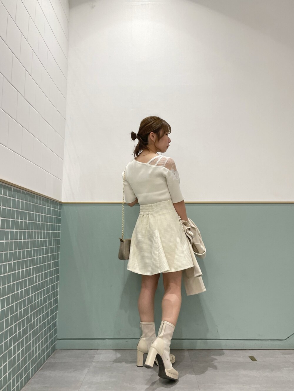 ホワイト系のライダースジャケット、ホワイト系のニット/セーター、ホワイト系のスカートを着用したレディースの春コーディネートの8枚目の写真