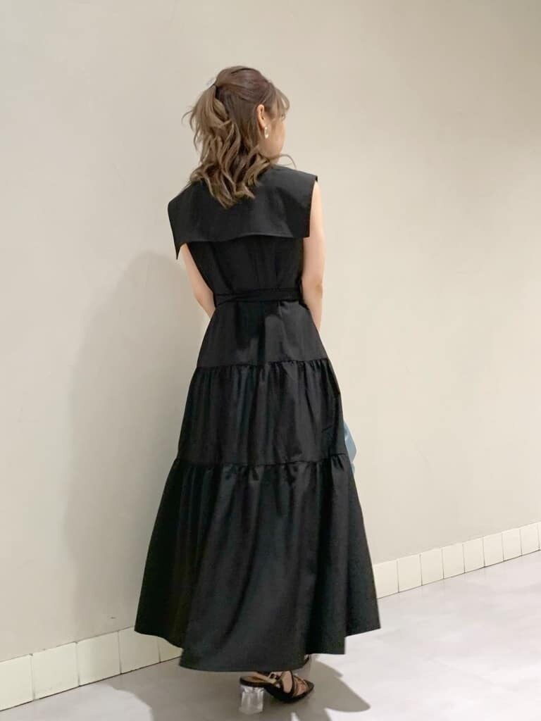 ブルー系のハンドバッグ、ブラック系のワンピース、ブラック系のサンダルを着用したレディースの春コーディネートの3枚目の写真