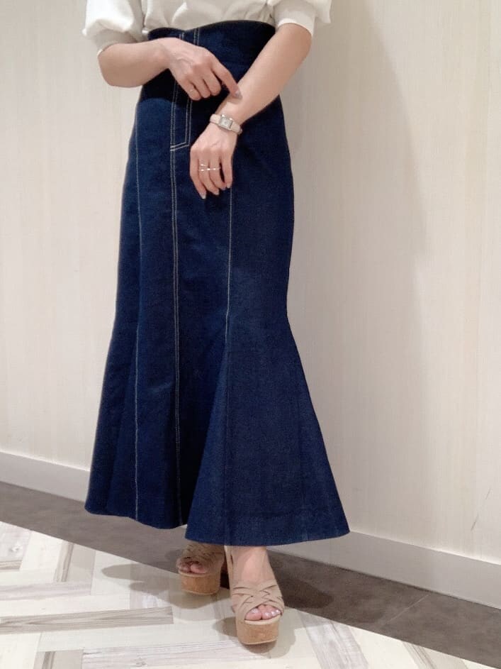 ブルー系のスカート、ホワイト系のニット/セーター、ベージュ系のサンダルを着用したレディースの春コーディネートの5枚目の写真