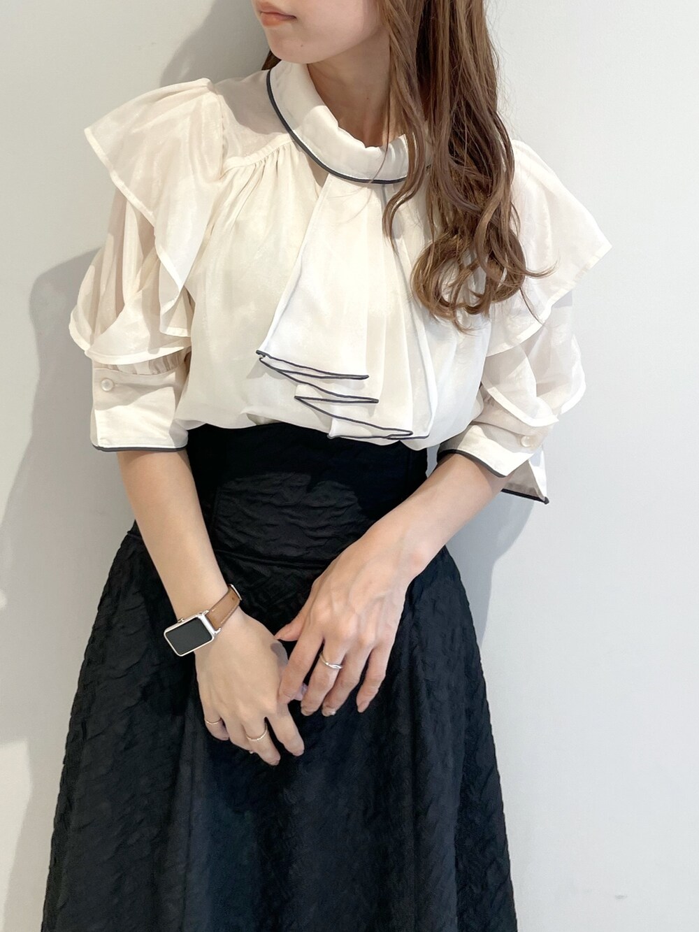 ホワイト系のシャツ/ブラウス、ブラック系のスカート、ブラック系のパンプスを着用したレディースの夏コーディネートの4枚目の写真