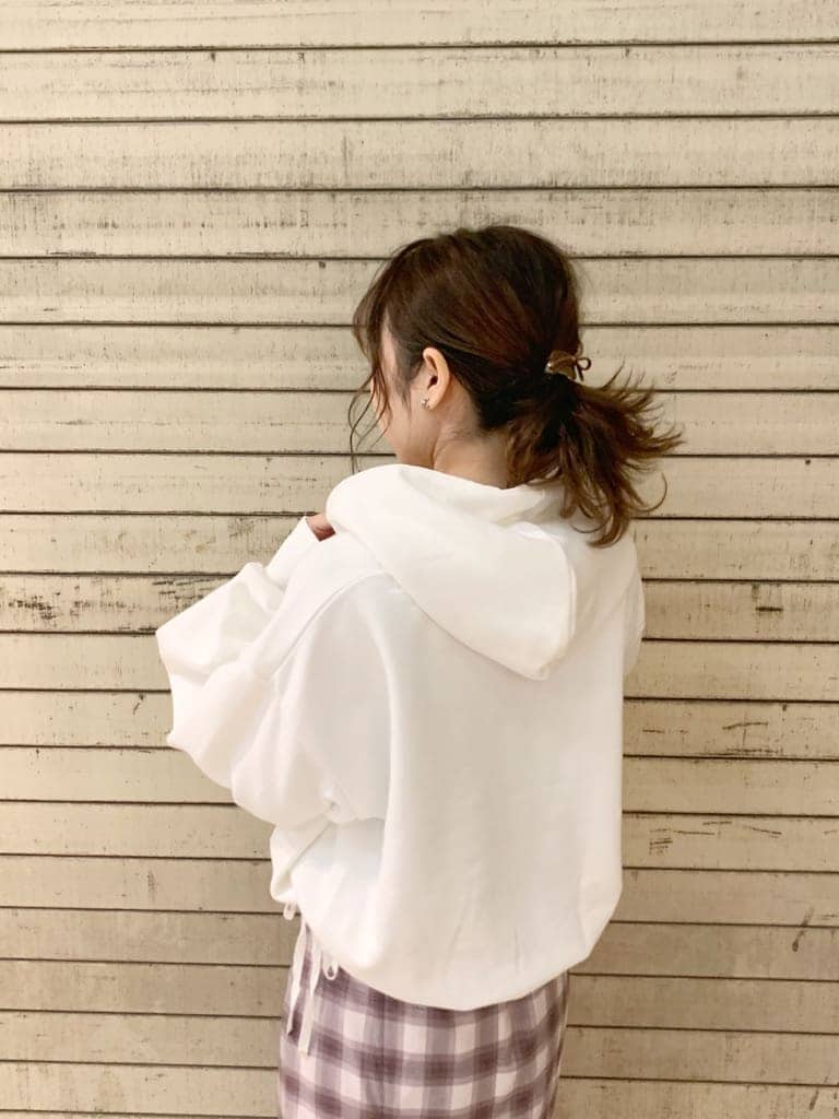 ホワイト系のパーカー、ベージュ系のブーツ、パープル系のスカートを着用したレディースの冬コーディネートの3枚目の写真