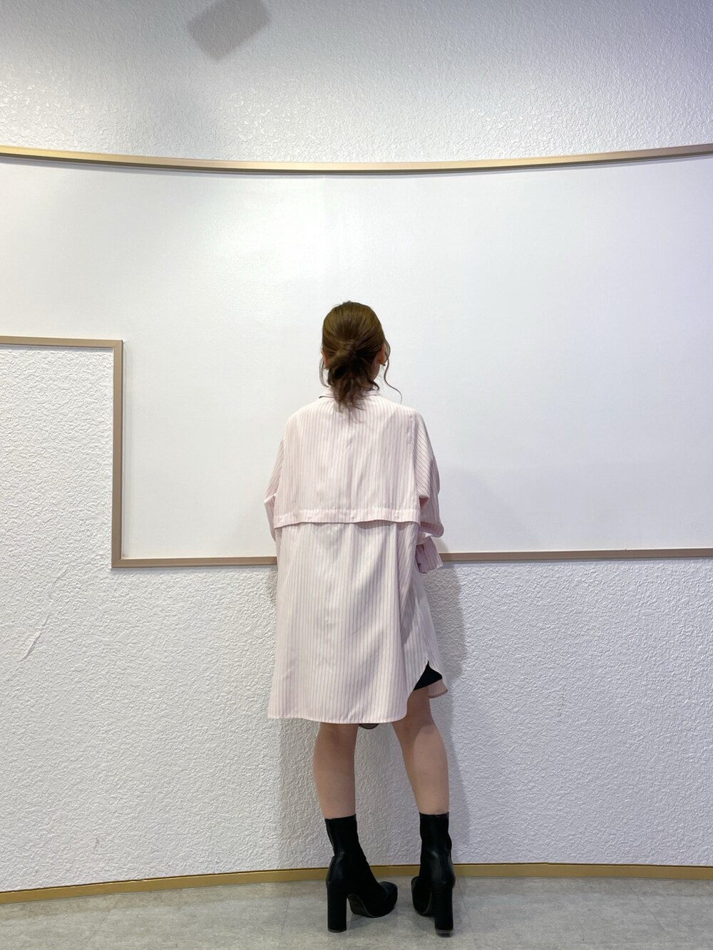 ピンク系のワンピース、ブラック系のブーツ、グレー系のスカートを着用したレディースの春コーディネートの4枚目の写真