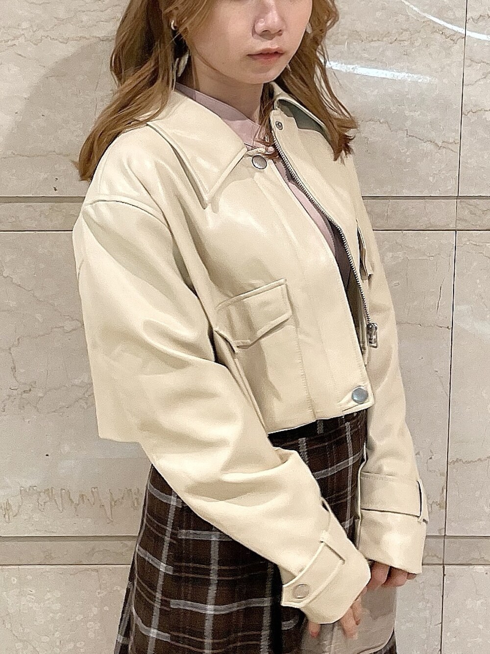 ホワイト系のライダースジャケット、ピンク系のシャツ/ブラウス、ブラウン系のスカートを着用したレディースの冬コーディネートの6枚目の写真